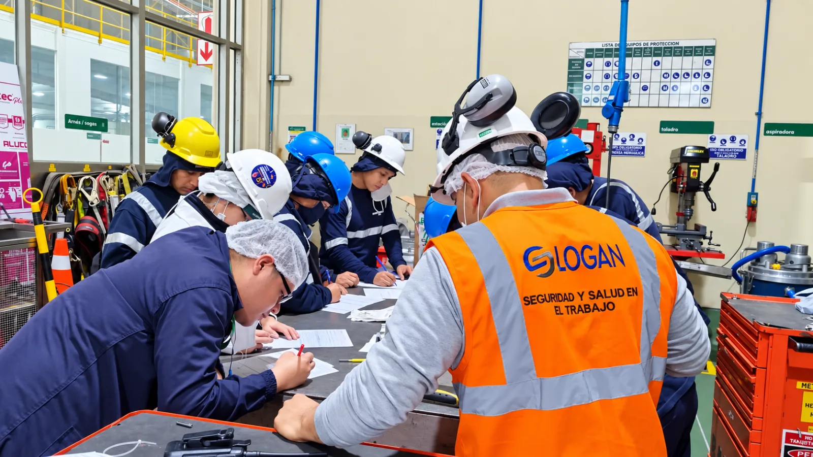 Supervisor de LOGAN guiando a un equipo con EPP mientras completa registros en planta